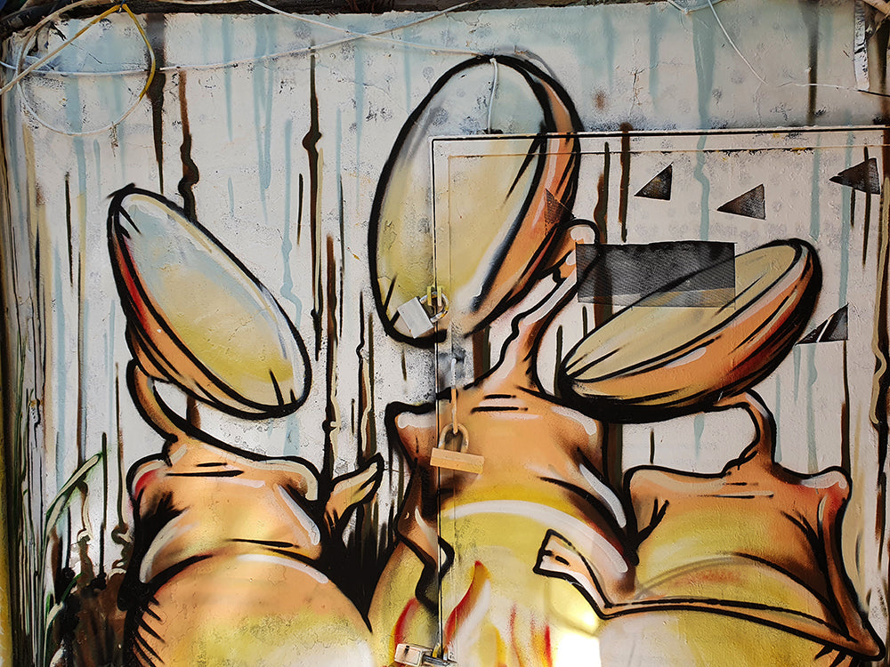 Damian Tab street art mural in Nachalat Binyamin Tel Aviv 2020 featuring surreal abstract characters around bonefire