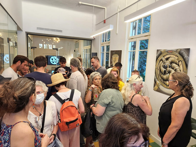 Visitors viewing artworks at the Damian Tab memorial exhibition in Tel Aviv