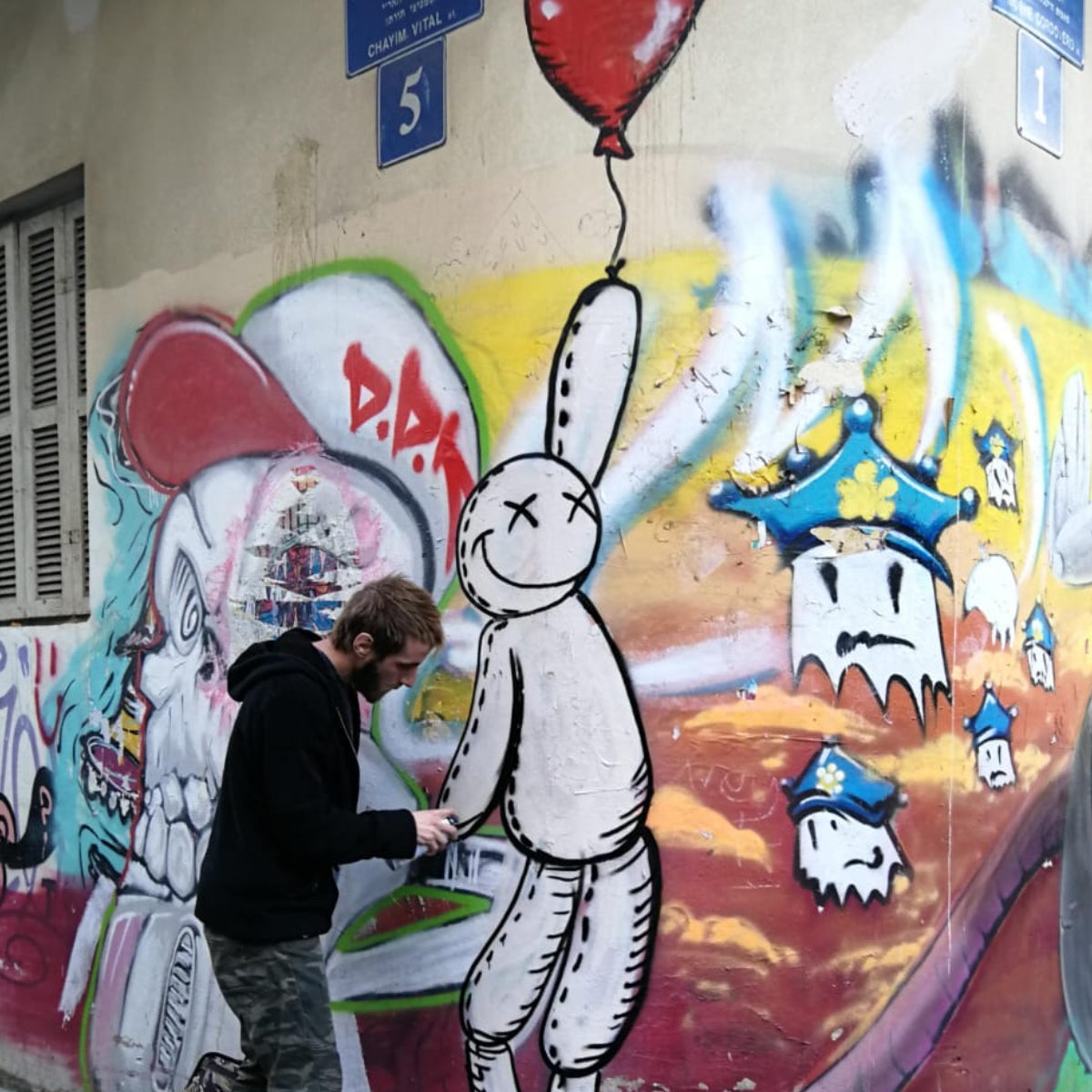 Damian Tab painting street art in Vital street in Tel aviv  spray painting mural in urban environment