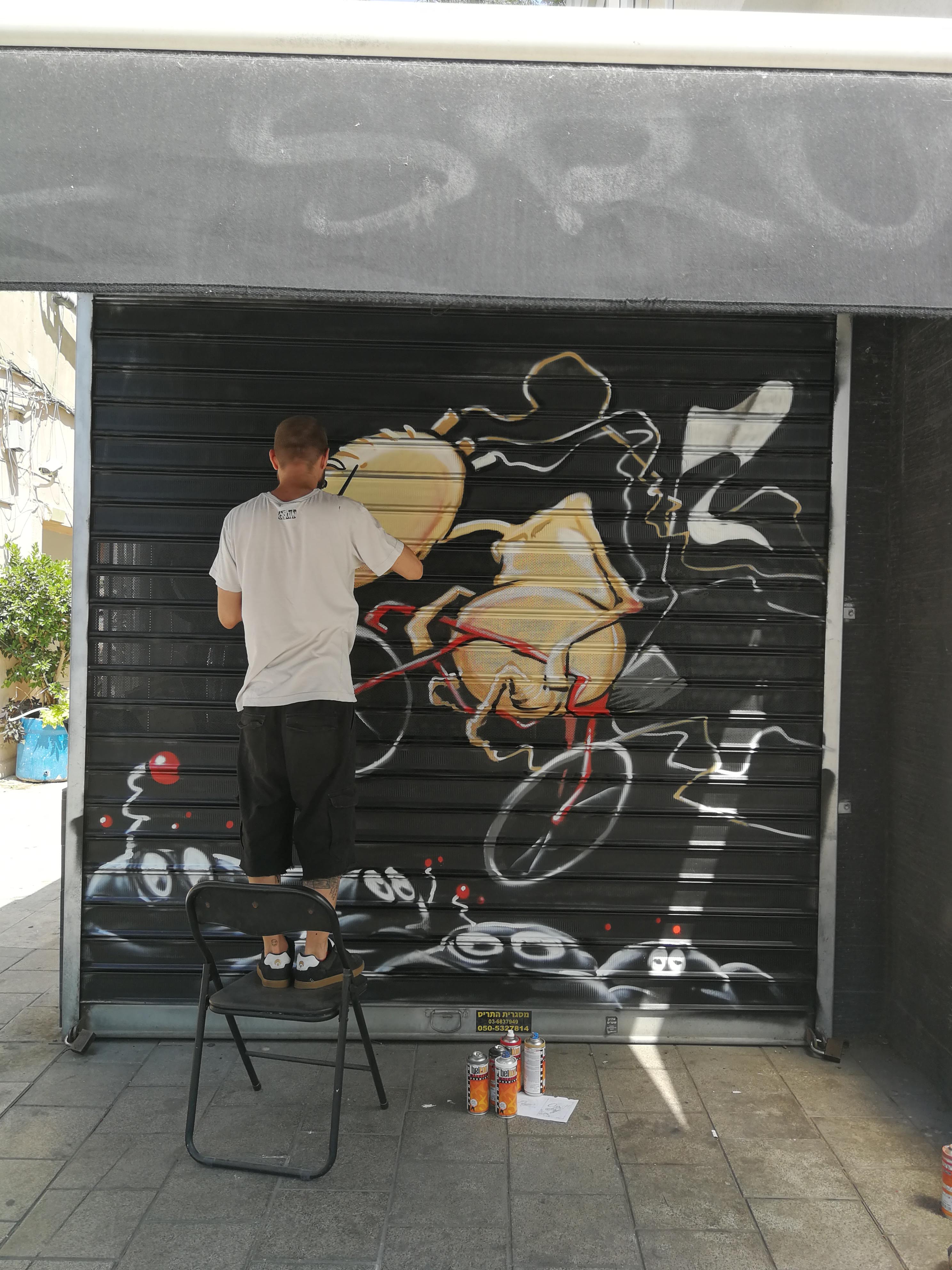 Damian Tab painting street art  in Tel Aviv Yehuda Halevi Seed on a bike